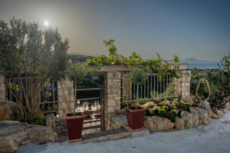 Stone built entrance to a wine tasting area surrounded by vegetation and grapevines.