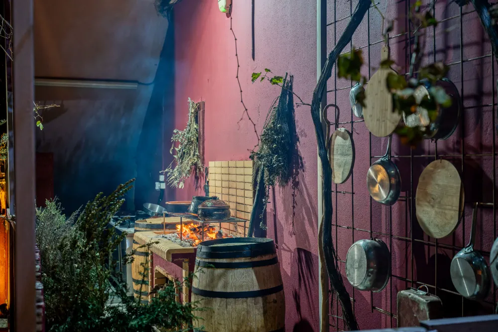 Traditional open kitchen grill with live fire a wine barrel and fresh herbs