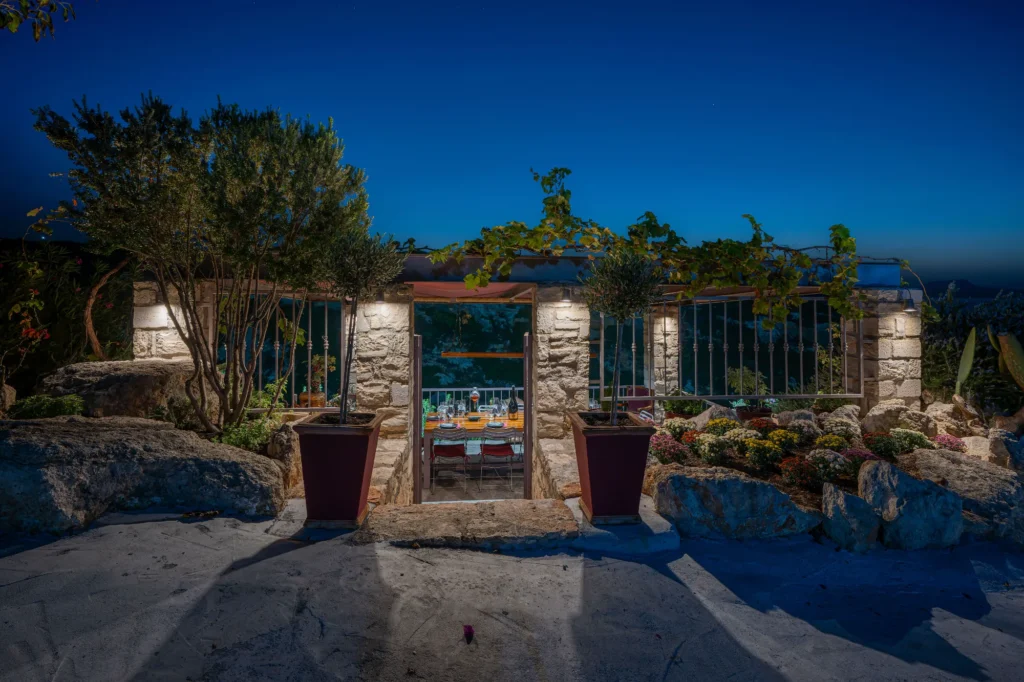 Stone built entrance to wine tasting space at night, lit up.